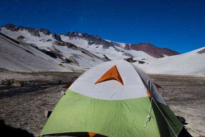 Umbrella on snow covered mountain against blue sky