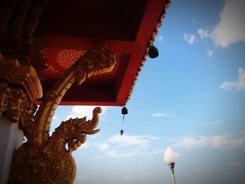 Low angle view of statue against sky and building