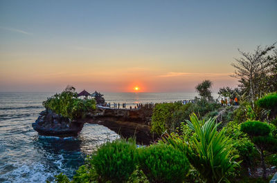 Tanah lot by sea against sky during sunset