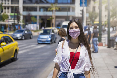 Full length of young woman standing on city street