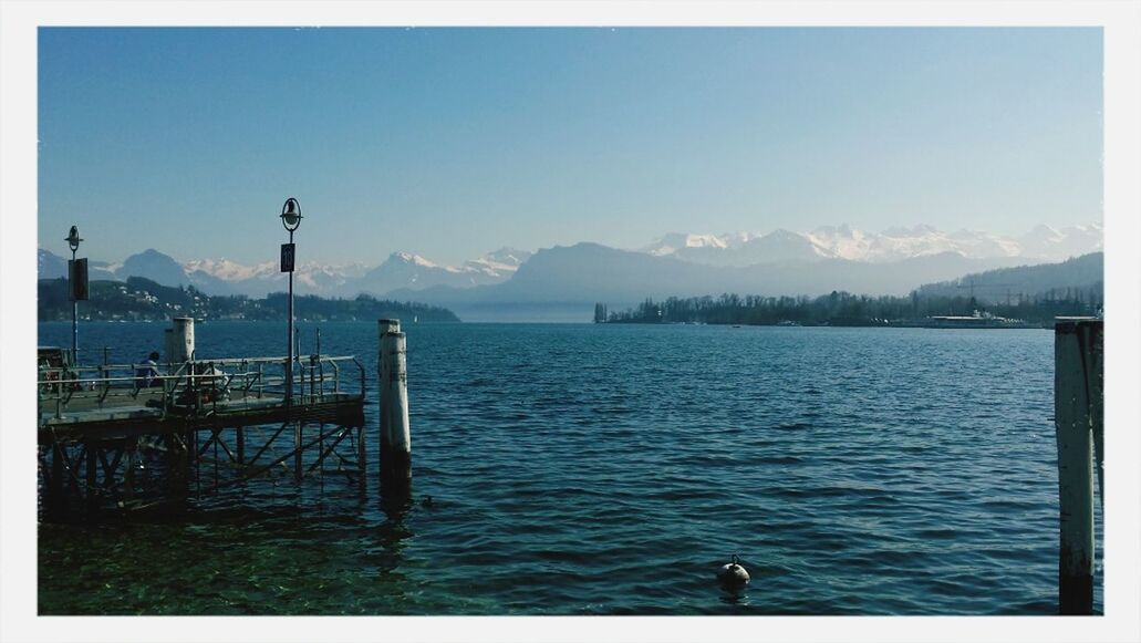 water, transfer print, animal themes, mountain, blue, sky, sea, scenics, tranquility, tranquil scene, auto post production filter, bird, beauty in nature, nature, one animal, rippled, lake, pier