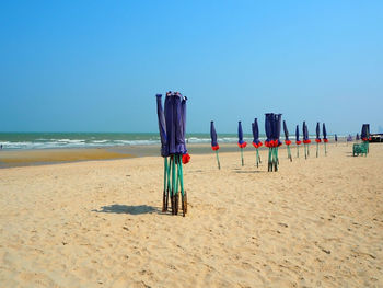 View of calm beach against clear blue sky