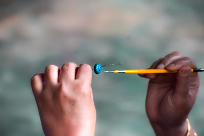 Close-up of man holding thermometer