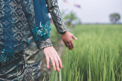 Close-up of woman hand on field