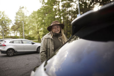 Smiling woman standing near car