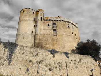 Low angle view of old building against cloudy sky