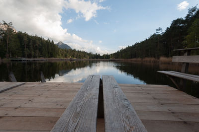 Wooden pier over lake against sky