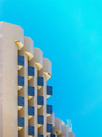 Close-up of stack of wooden structure against blue sky