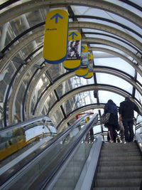 Rear view of people walking on escalator