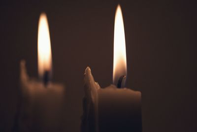Close-up of lit candle in darkroom