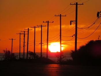 Silhouette of electricity pylon during sunset