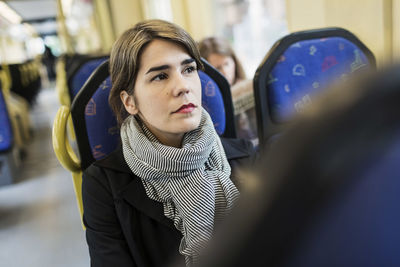 Thoughtful young woman looking away in tram