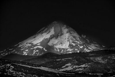 Scenic view of snowcapped mountains against sky at night