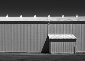 Architectural details of a agricultural shed against a blue sky taken in a minimalist style.