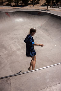 Full length of woman skateboarding at skateboard park