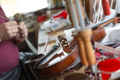 Midsection of woman repairing violin string