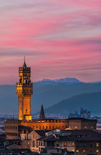 Illuminated cityscape against sky at sunset