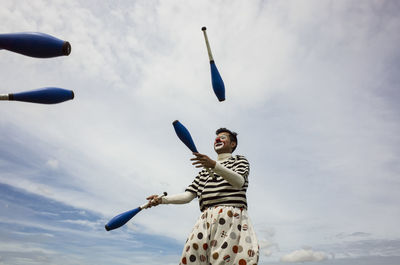 Low angle view of clown standing against sky