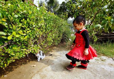 Side view of cute girl looking at cat