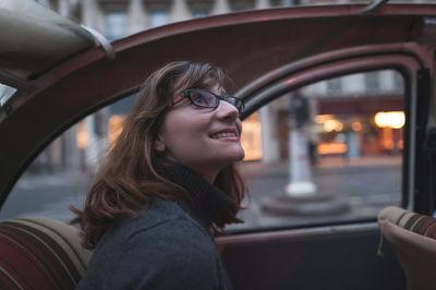 Close-up of young woman looking away while sitting in car