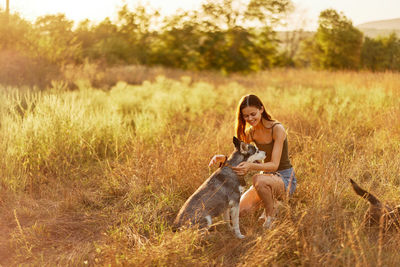 Young woman with dog on grassy field