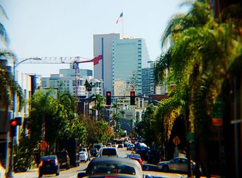 Traffic on city street leading towards skyscrapers