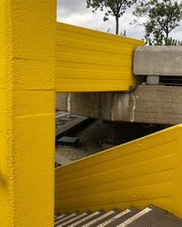 Close-up of yellow wall by plants against sky