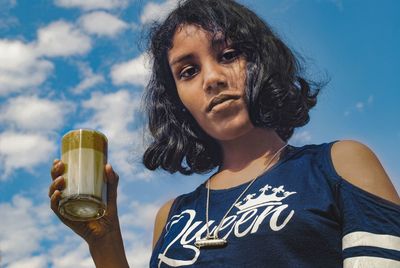 Portrait of young woman drinking glass