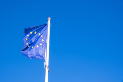 Eu european flag poole blowing in the wind. frayed european union flag is fluttered by strong wind