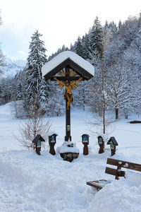 Gazebo on snow covered field against sky