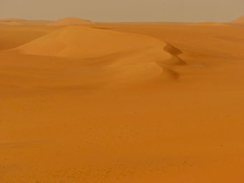 Scenic view of desert against orange sky