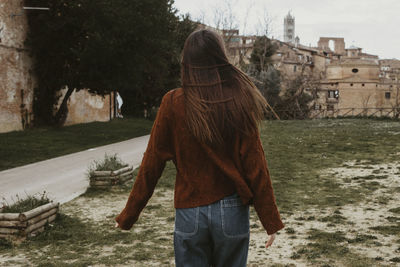 Rear view of woman standing by canal