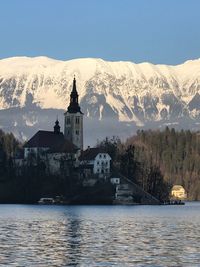 Scenic view of buildings by mountains against sky