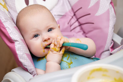 Portrait of cute baby girl eating food