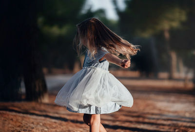 Rear view of woman standing on footpath