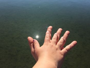 Close-up of hand against water
