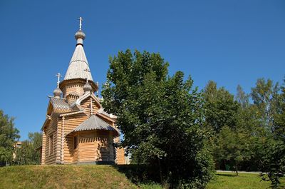 Low angle view of trees and church against sky