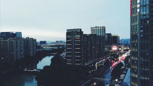 Illuminated buildings in city against sky