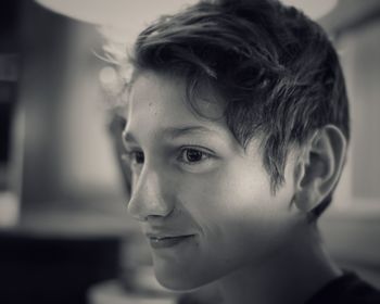 Close-up of smiling boy looking away at home