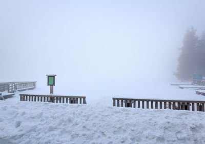 Snow covered land against clear sky