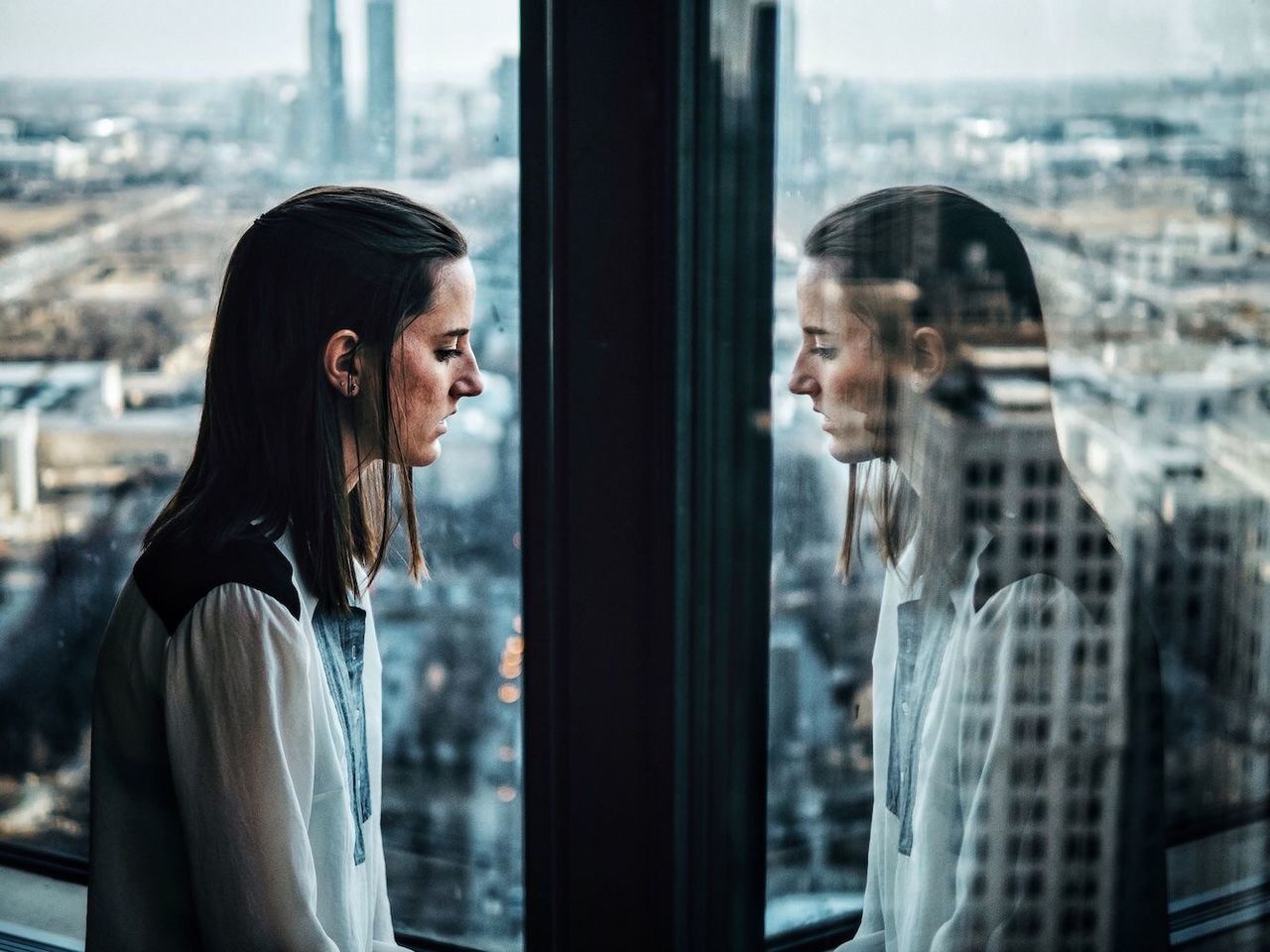 lifestyles, young adult, person, standing, waist up, leisure activity, casual clothing, focus on foreground, young women, three quarter length, window, glass - material, smiling, indoors, side view, front view, headshot