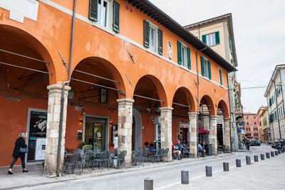 People walking on street by buildings in city