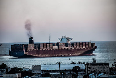 Commercial dock by sea against sky