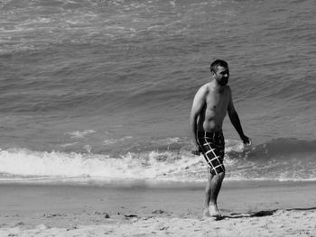 Full length of shirtless man on beach