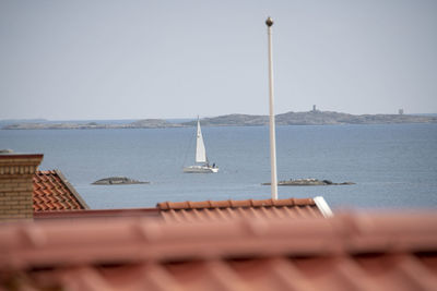 Sailboat sailing on sea against clear sky