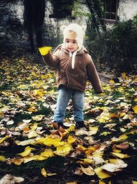 Full length of girl with autumn leaves