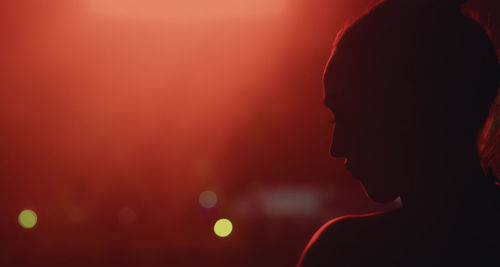 Close-up of silhouette woman at night