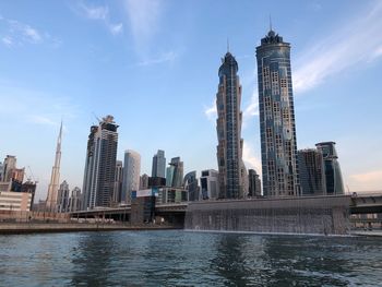 Low angle view of skyscrapers against cloudy sky