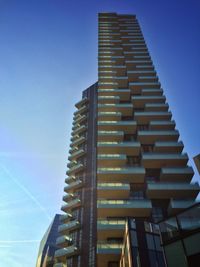 Low angle view of modern building against blue sky