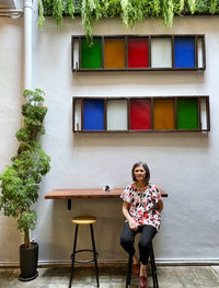 Full length portrait of woman sitting on table